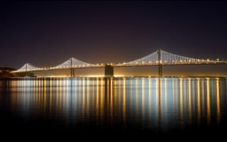 Картинка США, мост Бэй-Бридж, USA, вода, ночь, залив, Сан-Франциско, освещение, California, Bay Bridge, свет, Окленд, отражение, висячий, San Francisco, мост, Oakland, Калифорния, город