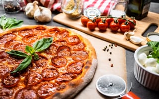 Картинка Пицца пепперони на столе с овощами и специями