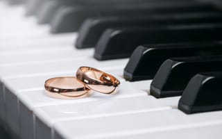 Картинка Два золотых обручальных кольца на клавишах рояля