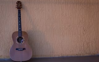 Картинка Шестиструнная гитара стоит у стены