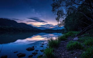 Картинка ночь, озеро, звёздное небо, HD, 1920х1080, сумрак, небесный купол, небосвод, ночная сцена, лунный свет, космос, гладь воды, водная гладь, тишина природы, 7к, зеркальная поверхность, 4k, природная гармония, темнота, нейросеть, камни у воды, звёзды, облака, тишина, умиротворение, горы, звёздная россыпь, пейзаж, прибрежная растительность, рабочий стол, природа, 2k, ИИ, спокойствие, 16:9, зеркальное отражение, лес, отражение