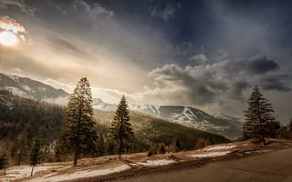 Обои склон, вершины, облака, горы, солнце, деревья, дорога, пейзаж, снег, Румыния, небо