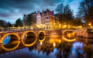 Картинка Amsterdam, освещение, город, вода, река, небо, вечер, дома, огни, деревья, канал, мост, тучи, фонари, улицы, Нидерланды, Амстердам, Nederland, отражение