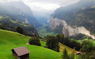 Обои Швейцария, Lauterbrunnen, дымка, горы, ущелье, панорама, скалы, деревья, деревня, склон, домики, долина