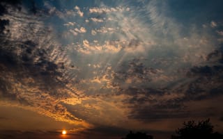 Картинка Солнце на закате освещает перистые облака
