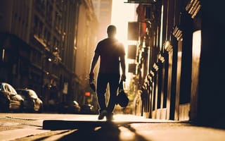 Картинка Мужчина идет по улице навстречу солнцу