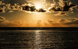 Картинка Солнечные лучи пробиваются сквозь облака над океаном