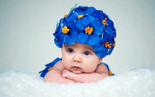 Картинка Маленький ребенок в красивой шапке с голубыми цветами
