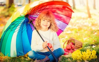 Картинка Улыбающаяся девочка под сидит под разноцветным зонтом