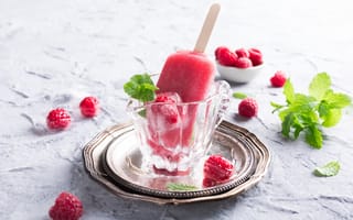 Обои Малиновое мороженое на палочке в стеклянном стакане на столе со свежими ягодами