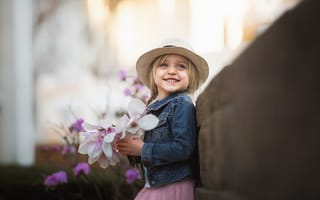 Картинка Маленькая голубоглазая улыбающаяся девочка в шляпе с букетом в руках