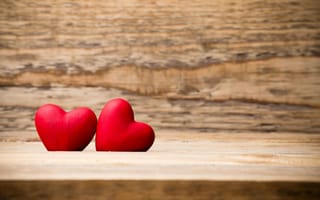 Картинка Два красных сердца лежат на деревянной лавке