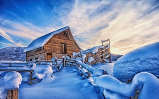 Картинка Покрытый снегом дом в горах под красивым небом