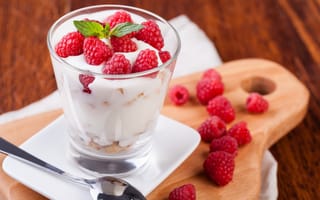 Обои Десерт с йогуртом и свежей малиной в стеклянном стакане на столе