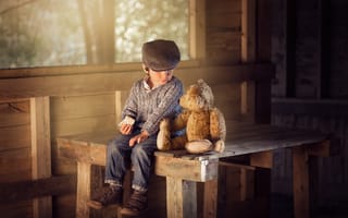 Картинка Маленький мальчик сидит на деревянном столе с медвежонком Тедди