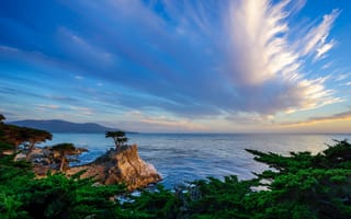 Картинка Скалистый морской берег под голубым небом с красивыми белыми облаками