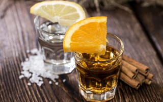 Картинка Рюмка водки и рюмка виски на столе с кусочками лимона