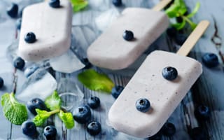 Картинка Вкусное мороженое с ягодами черники на столе с кусочками льда
