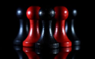 Обои Красные и черные шахматные фигуры на черном фоне
