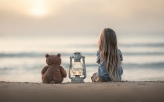 Картинка Маленькая девочка сидит на песке с плюшевым мишкой