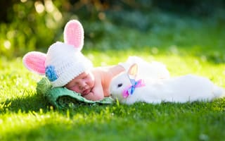 Картинка Маленький спящий грудной ребенок на зеленой траве с белым кроликом