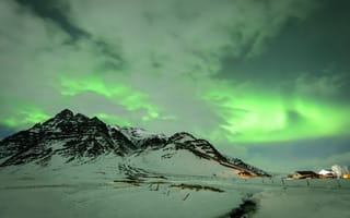 Картинка Зеленое северное сияние над заснеженными горами в Исландии зимой