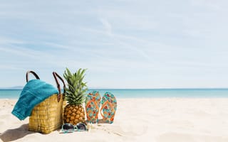 Картинка Сумка, ананас, шлепанцы и солнечные очки лежат на песке на пляже летом