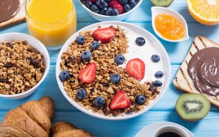 Картинка Мюсли с ягодами и молоком в тарелке на столе к завтраку