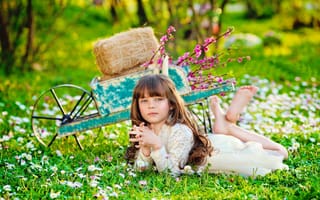 Картинка Маленькая девочка лежит на зеленой траве
