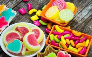 Картинка Разноцветный мармелад с конфетами на деревянном столе