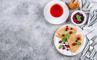 Картинка Тонкие блинчики на столе с ягодами, чаем и медом