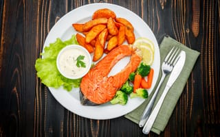 Картинка Кусок красной рыбы на тарелке с картофелем и соусом