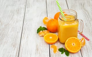 Картинка Свежий сок в стеклянной банке на столе с апельсинами