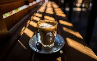 Картинка Стакан с кофе стоит на деревянном лавке