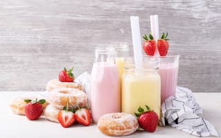Картинка Молочные коктейли на столе с пончиками и ягодами клубники