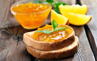 Картинка Два кусочка хлеба с апельсиновым джемом на столе с мятой