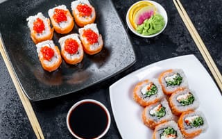 Картинка Суши с красной икрой и рыбой на столе с соусом и палочками