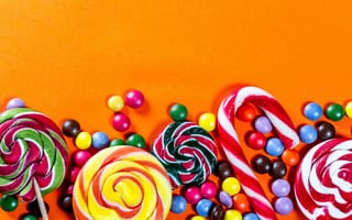 Картинка Разноцветные конфеты на оранжевом фоне