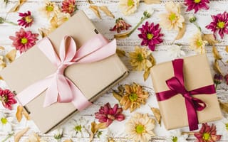 Обои Две коробки с подарками на столе с цветами хризантемы