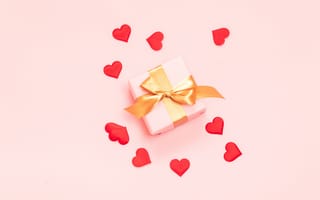 Картинка Подарок с бантом на розовом фоне с красными сердечками