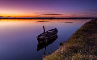 Картинка Старая лодка стоит в воде на закате солнца