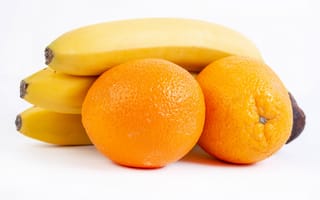 Обои Спелые апельсины и бананы на белом фоне