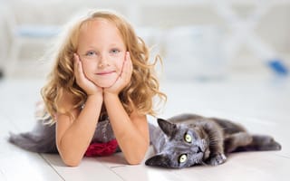 Картинка Маленькая милая голубоглазая девочка лежит на полу с котом