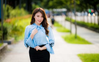 Картинка Красивая азиатка в голубой блузке и черной юбке