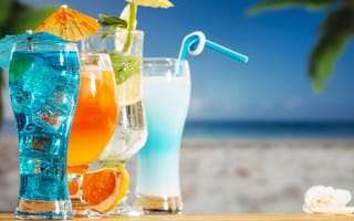 Обои Четыре коктейля стоят на столе пляже