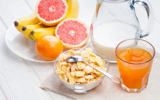 Картинка Кукурузные хлопья на столе с молоком, соком и свежими фруктами на завтрак