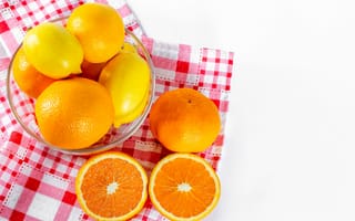 Картинка Спелые апельсины и лимоны в стеклянной миске на столе