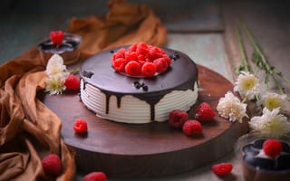 Картинка Вкусный торт с шоколадом и малиной на столе с цветами хризантемы