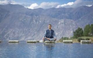 Картинка Мужчина азиат в позе лотоса медитирует у воды