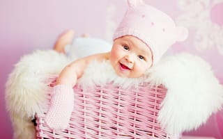 Картинка Улыбающийся грудной ребенок в шапке в розовой корзине